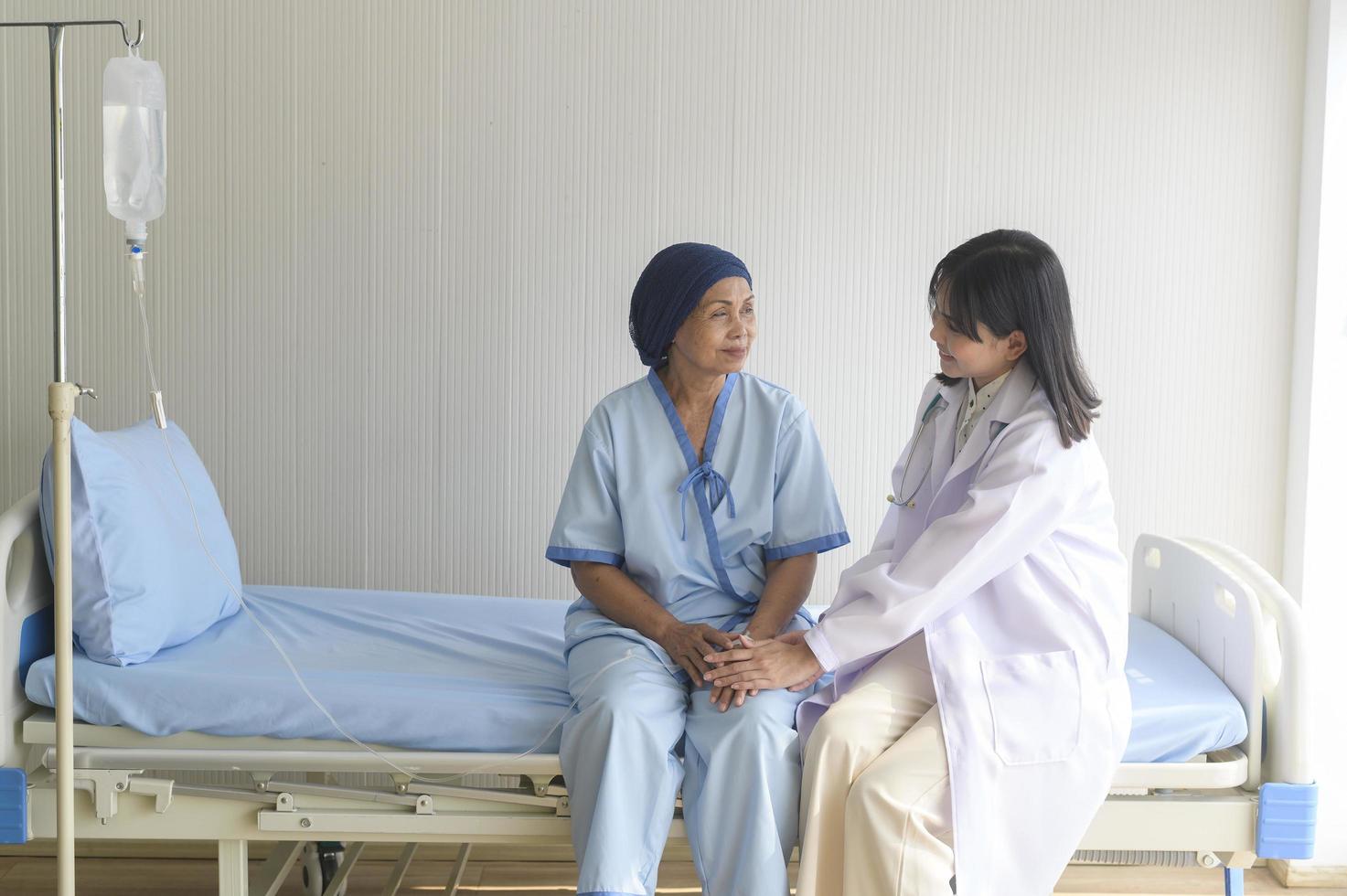 Doctor holding senior cancer patient's hand in hospital, health care and medical concept photo