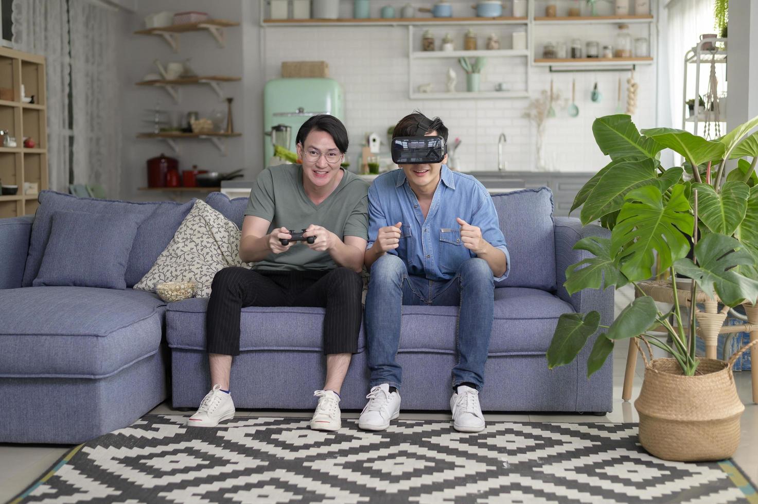 joven pareja gay sonriente jugando videojuegos en la sala de estar en casa, lgbtq y diversidad foto