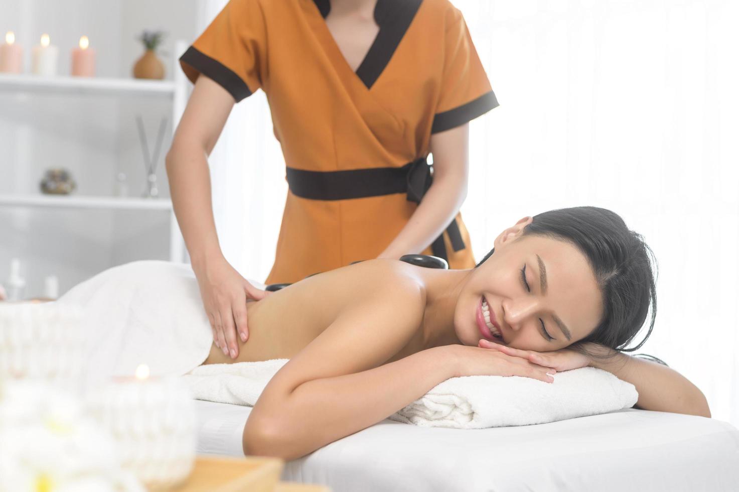 Young asian beautiful woman relaxing and enjoying massage, spa and beauty treatment concept photo