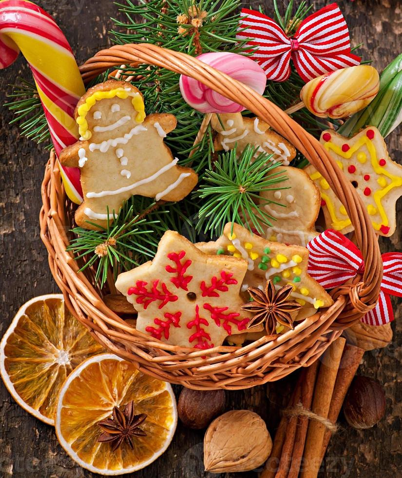Christmas gingerbread cookies and lollipops in a basket on old wooden background photo