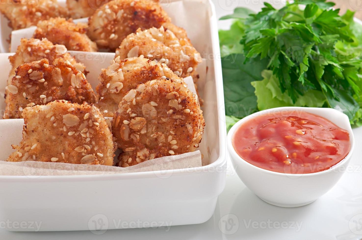 Chicken nuggets coated in cereals, crumbs and sesame photo