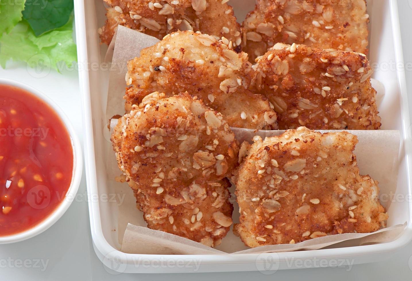 Chicken nuggets coated in cereals, crumbs and sesame photo