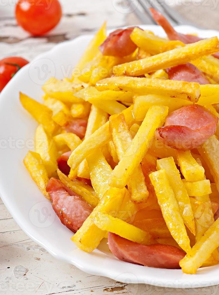patatas fritas con chorizo en un plato foto