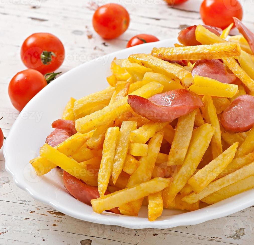 patatas fritas con chorizo en un plato foto