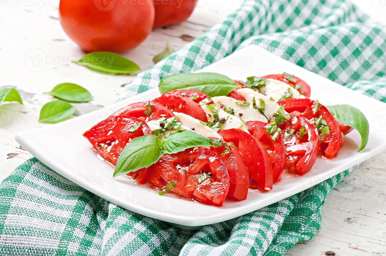 Caprese Salad. Tomato and Mozzarella slices with basil leaves. photo