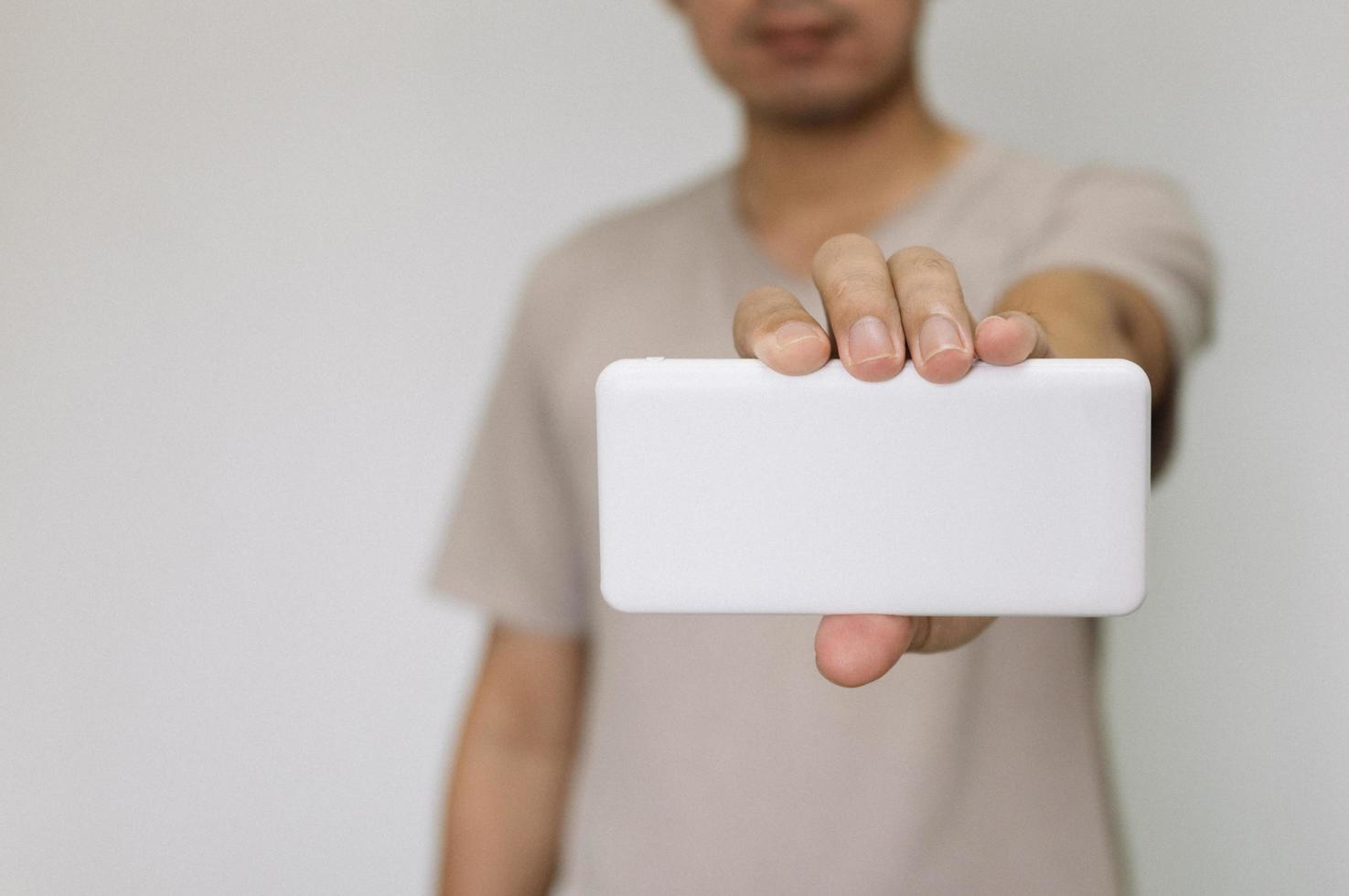 Close up man holding white power bank. man wearing brown shirt holding energy reserves. photo