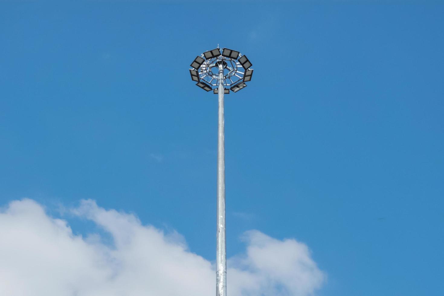 Tall steel mast with powerful searchlights against the sky. photo