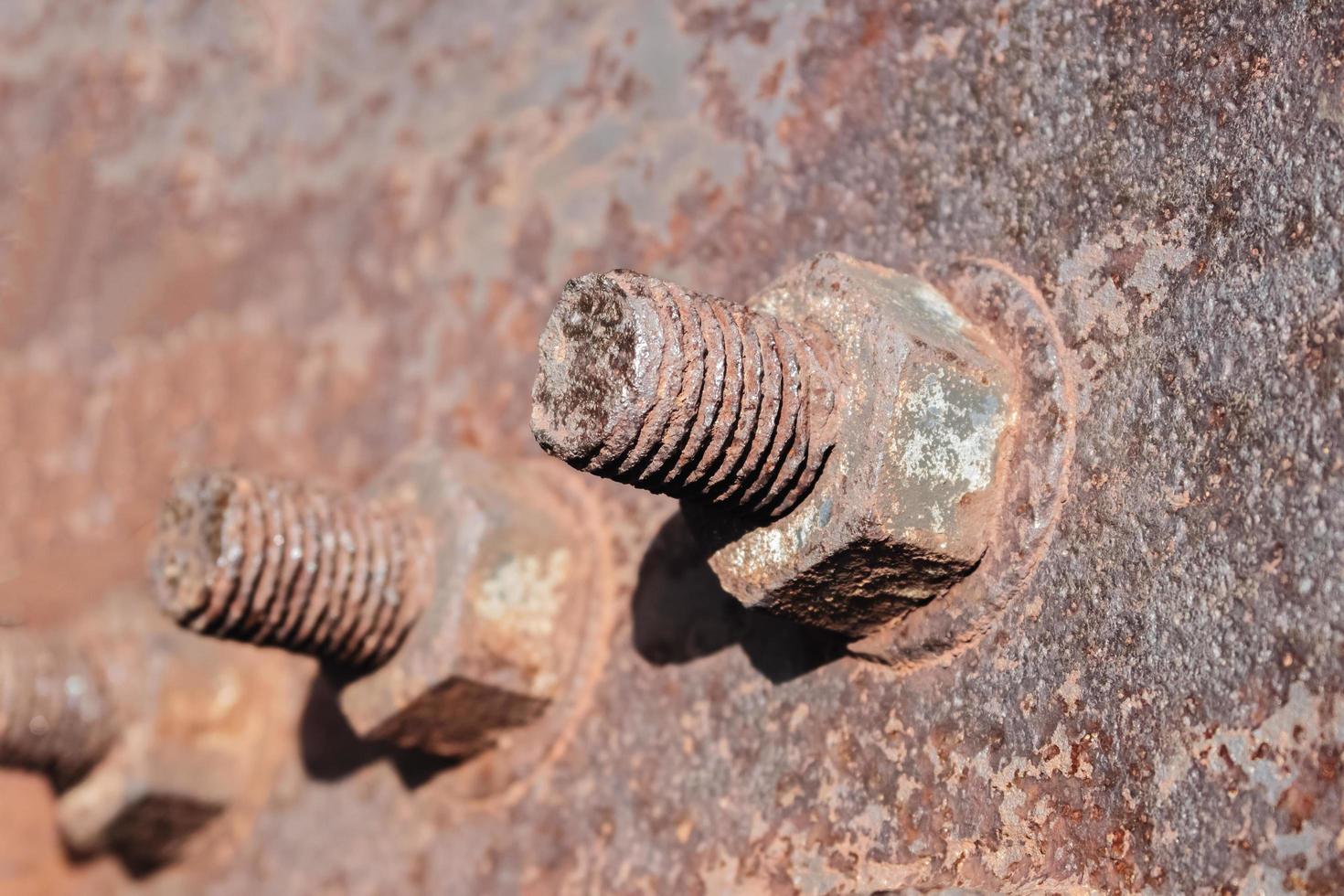 Tuercas y tornillos oxidados en una antigua estructura metálica. foto