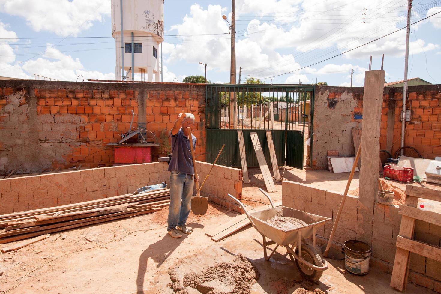 planaltina goias, brasil, 16 de abril de 2022 un hombre mezclando cemento con una pala para poner ladrillos. foto