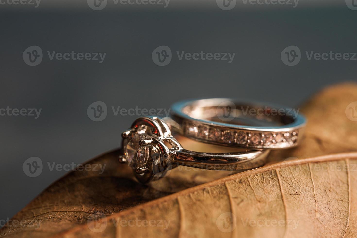 primer plano de un anillo de compromiso de diamantes colocado en una hoja. concepto de amor y boda. foto