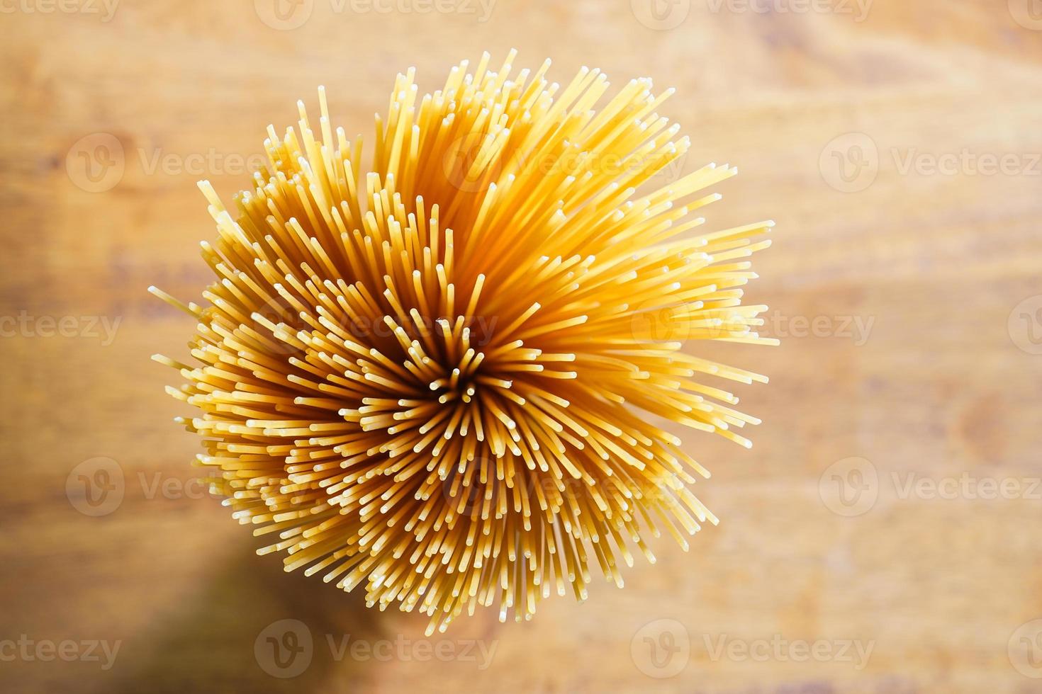 espaguetis largos amarillos sobre un fondo rústico. pasta italiana amarilla. espaguetis largos. espaguetis crudos a la boloñesa. espaguetis crudos. concepto de fondo de alimentos. concepto de menú y comida italiana. foto