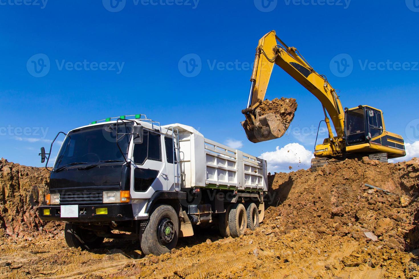 Backhoe digging and trucks. photo