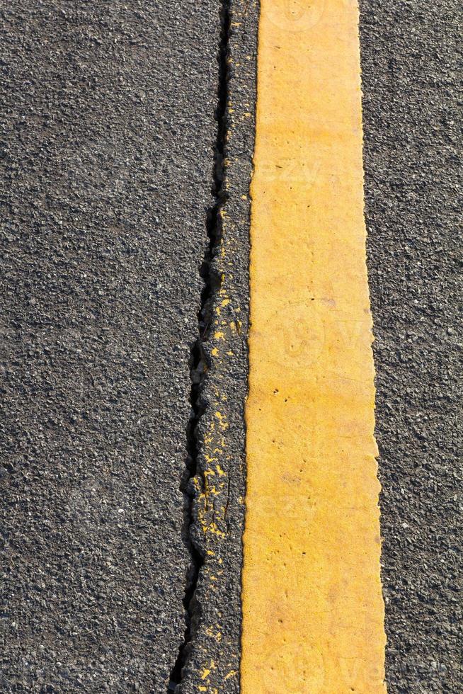 Cracked asphalt Yellow line photo