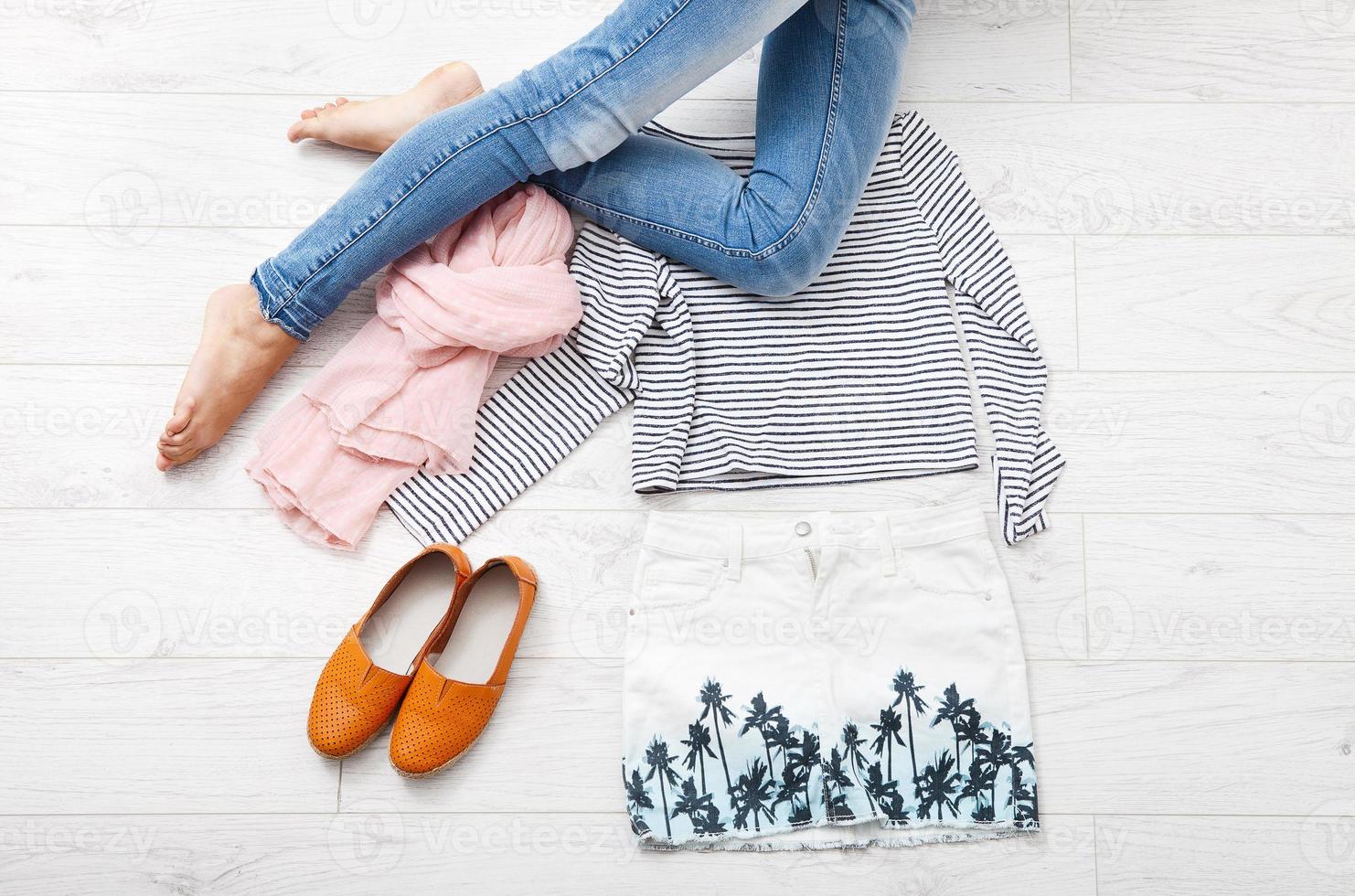 Collection collage of women's clothing and female legs on white wooden background. Top view photo