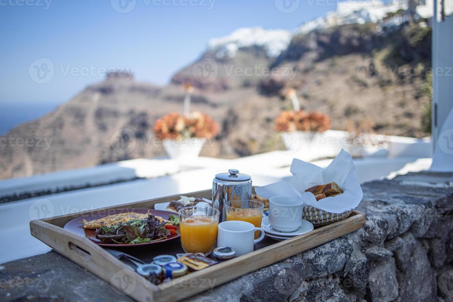 Breakfast time in Santorini in hotel. Luxury mood with fresh omelet and fruits with juice over sea view. Luxurious summer traveling holiday background. Happy relax vibes, couple morning closeup table photo