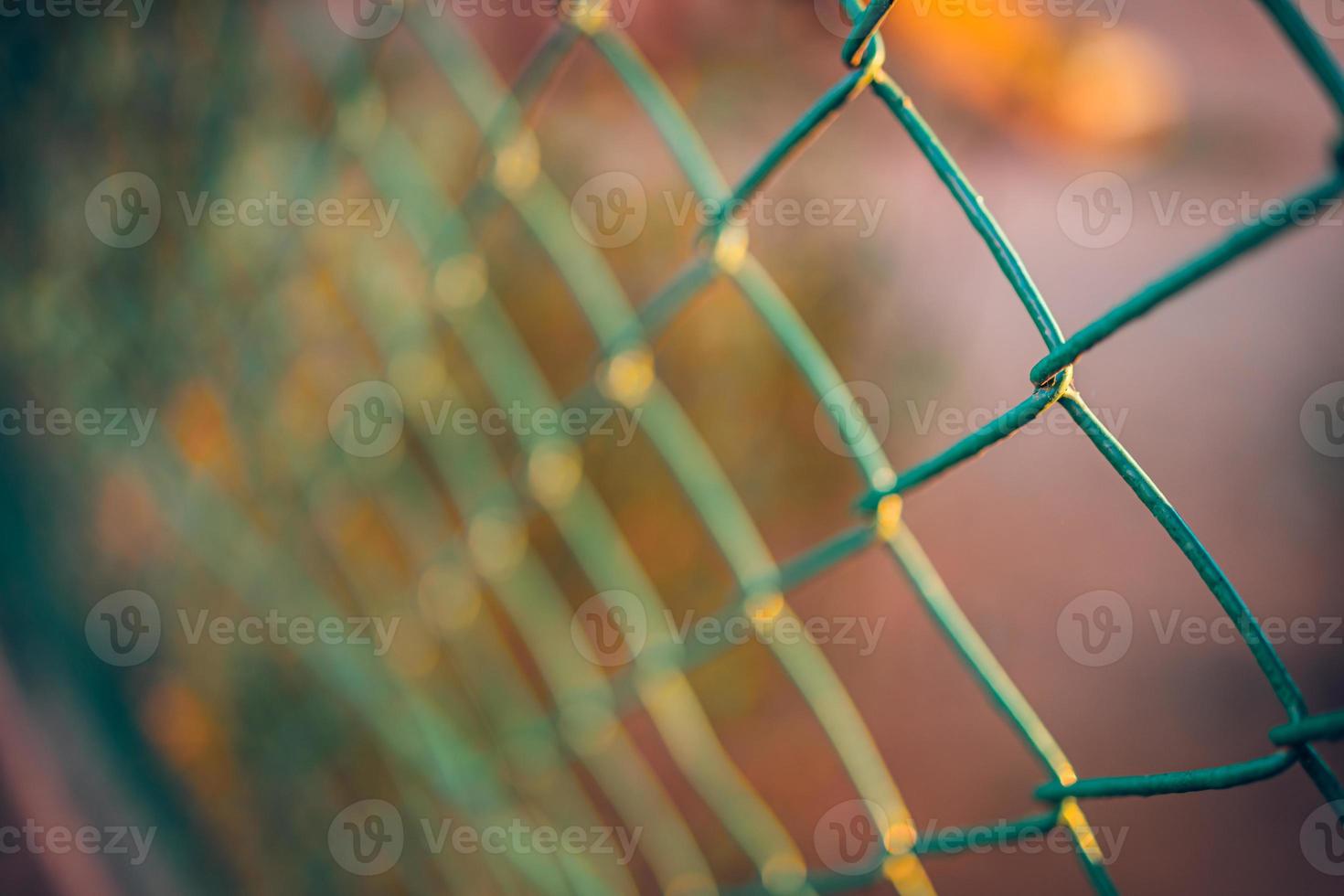 Wire fence blurred artistic background. Sunset warm colors, iron fence bokeh photo