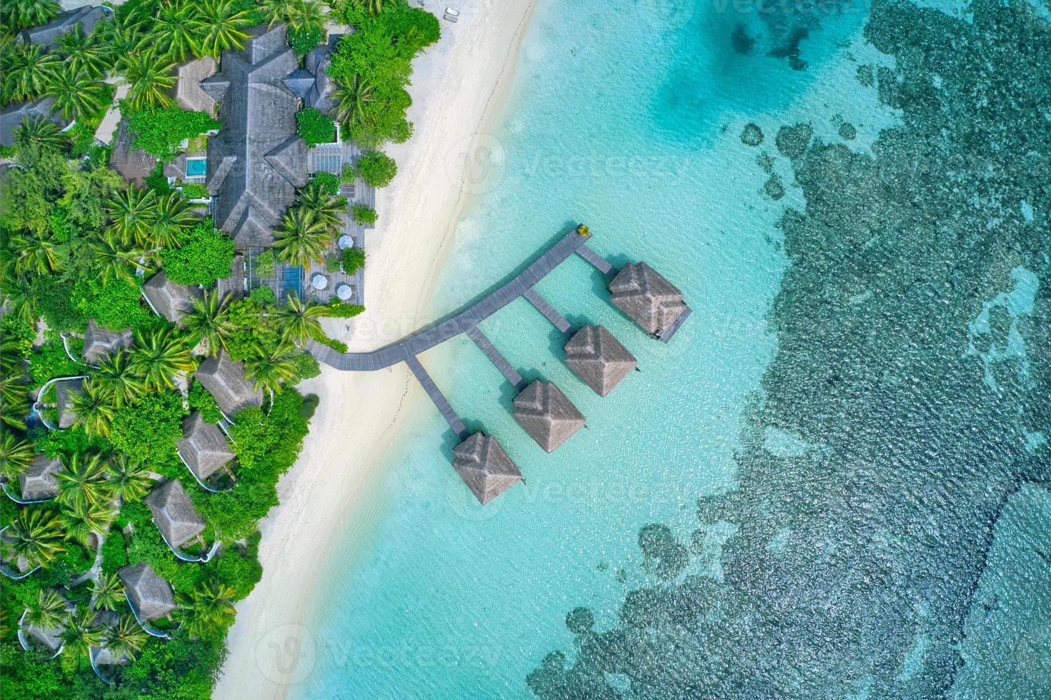 paisaje del paraíso de maldivas. paisaje aéreo tropical, paisaje marino con embarcadero largo, villas de agua con un mar increíble y una playa laguna, naturaleza tropical. banner de destino de turismo exótico, vacaciones de verano foto