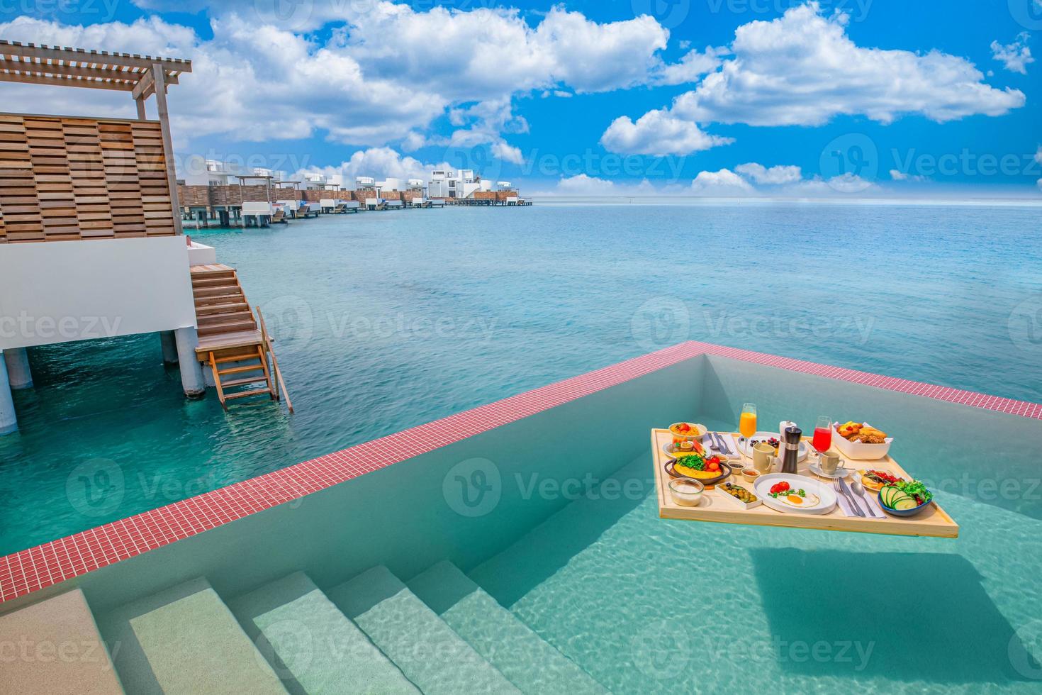 Breakfast in swimming pool, floating breakfast in tropical resort. Table relaxing in calm pool water, healthy breakfast and fruit plate by resort pool. Exotic summer diet luxury island beach lifestyle photo