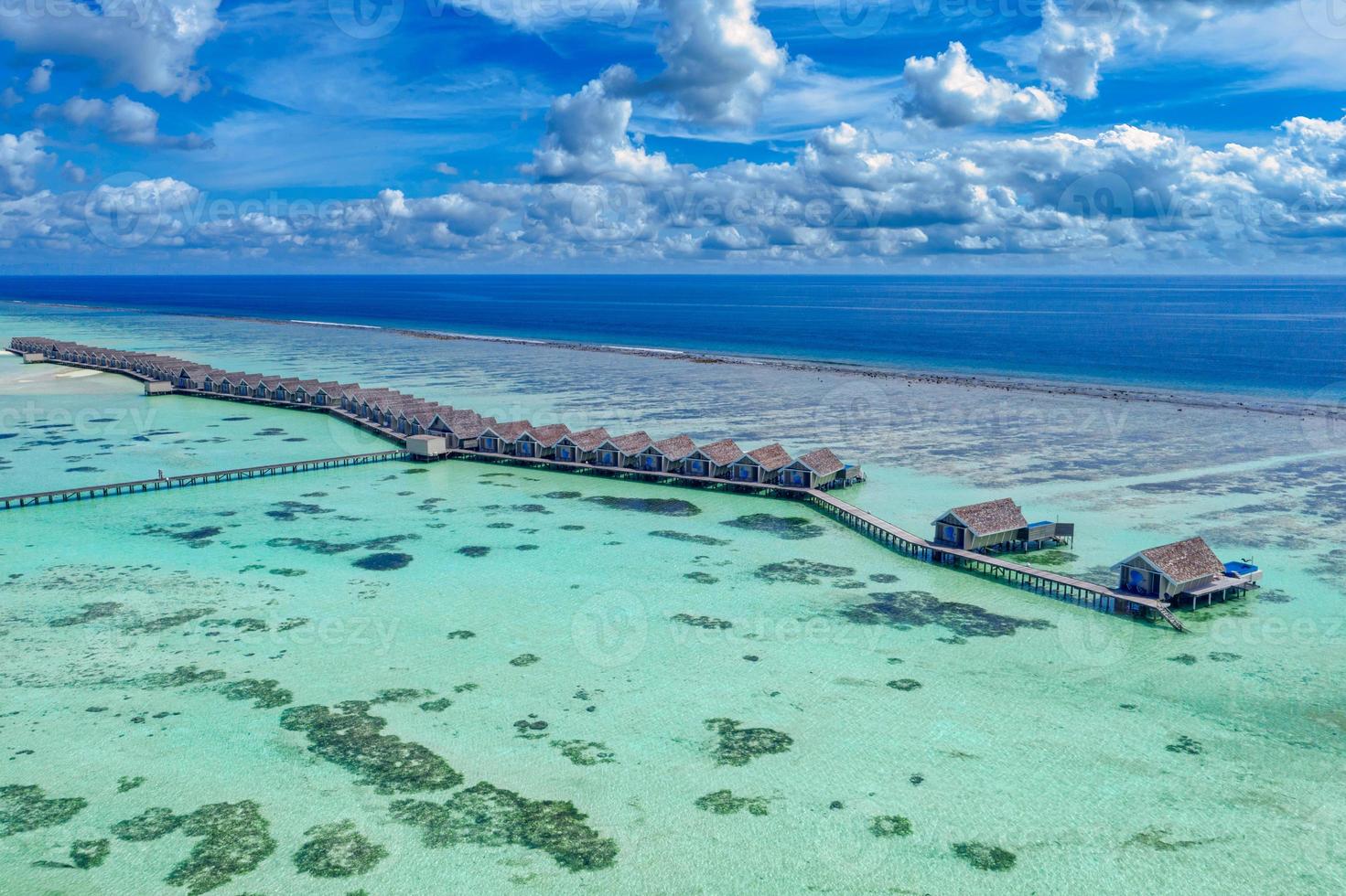 paisaje del paraíso de maldivas. paisaje aéreo tropical, paisaje marino con embarcadero largo, villas de agua con un mar increíble y una playa laguna, naturaleza tropical. banner de destino de turismo exótico, vacaciones de verano foto