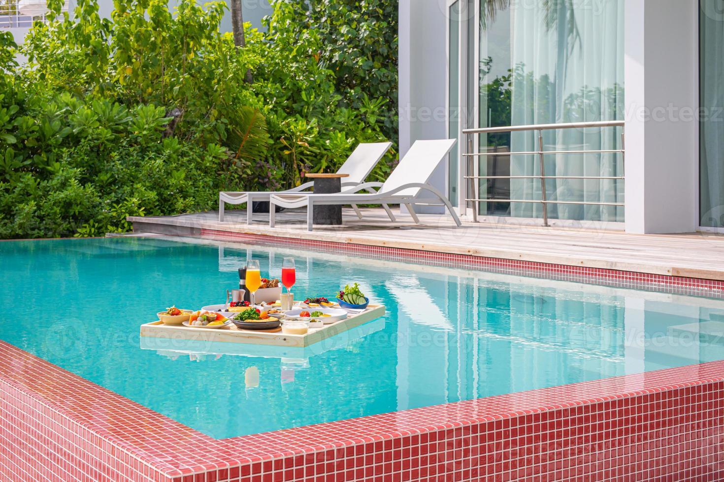 Breakfast in swimming pool, floating breakfast in tropical resort. Table relaxing in calm pool water, healthy breakfast and fruit plate by resort pool. Exotic summer diet luxury island beach lifestyle photo