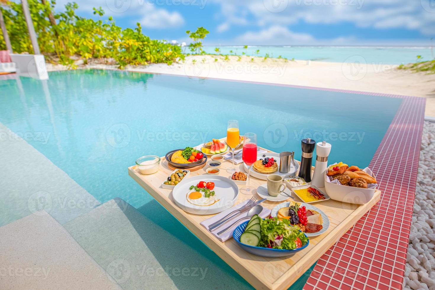 Breakfast in swimming pool, floating breakfast in tropical resort. Table relaxing in calm pool water, healthy breakfast and fruit plate by resort pool. Exotic summer diet luxury island beach lifestyle photo