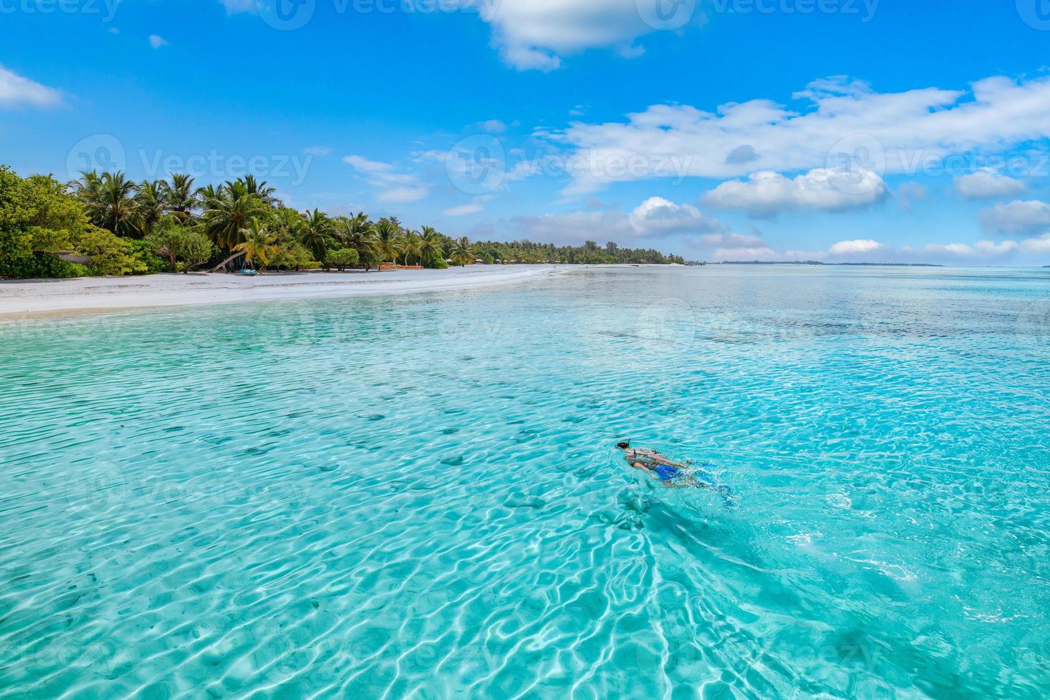 pareja caucásica de turistas bucean en agua cristalina turquesa cerca de la isla de maldivas. condiciones climáticas perfectas en la escena de la playa del resort de lujo, aguas tranquilas del mar, pareja de aguas exóticas, vida silvestre submarina foto