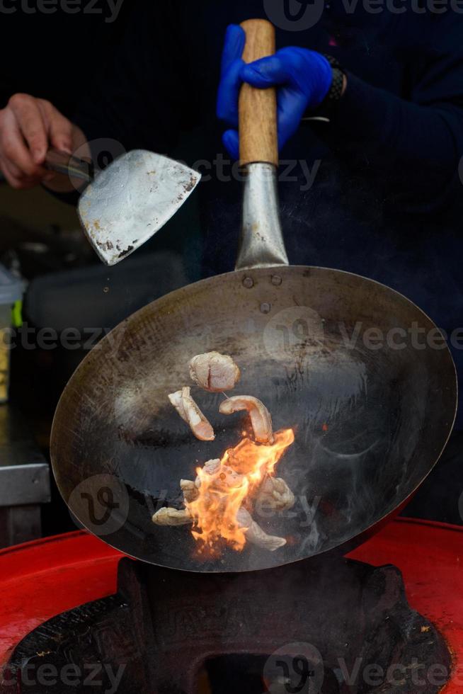 A chef prepares Chinese food at a street food festival. photo