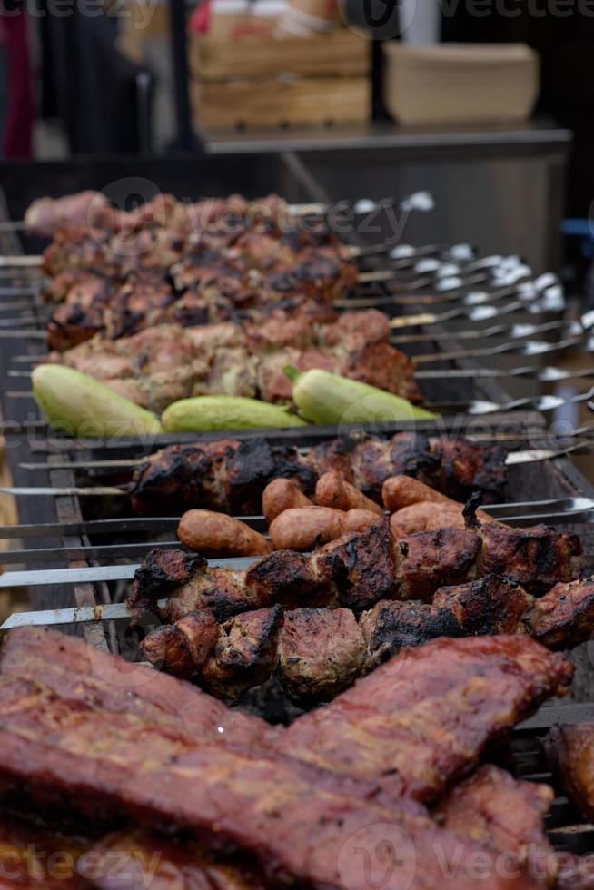 brochetas de carne a la parrilla sobre las brasas, con humo. comida de la calle. foto