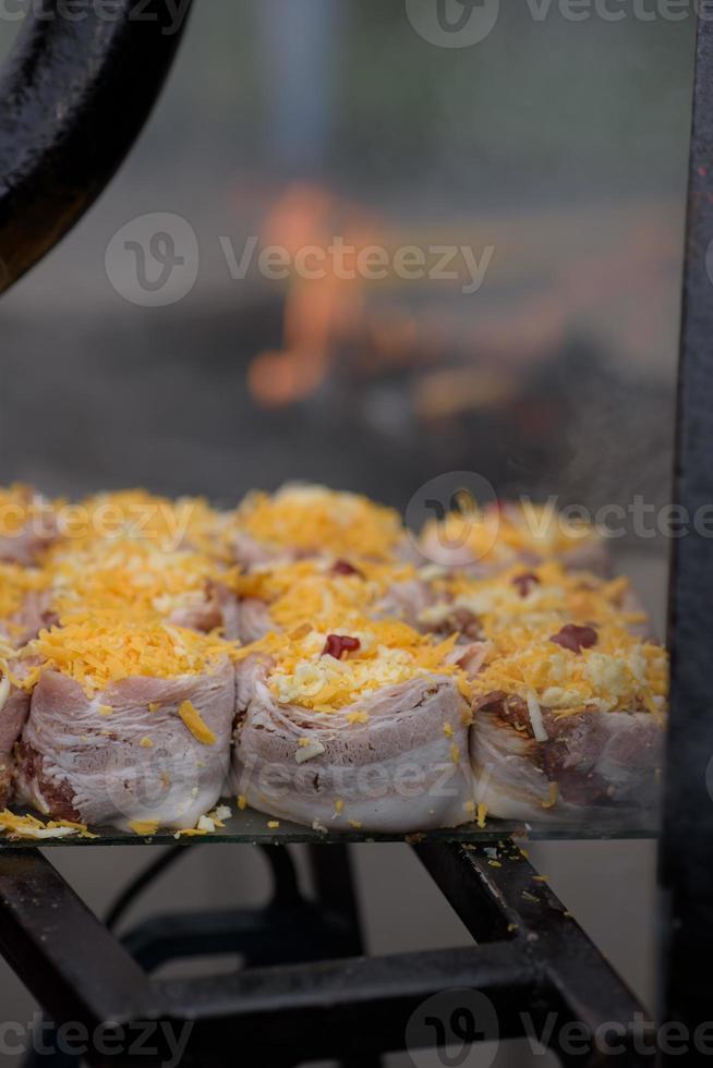Handmade hamburger patties during the street food festival, smoke while cooking. photo