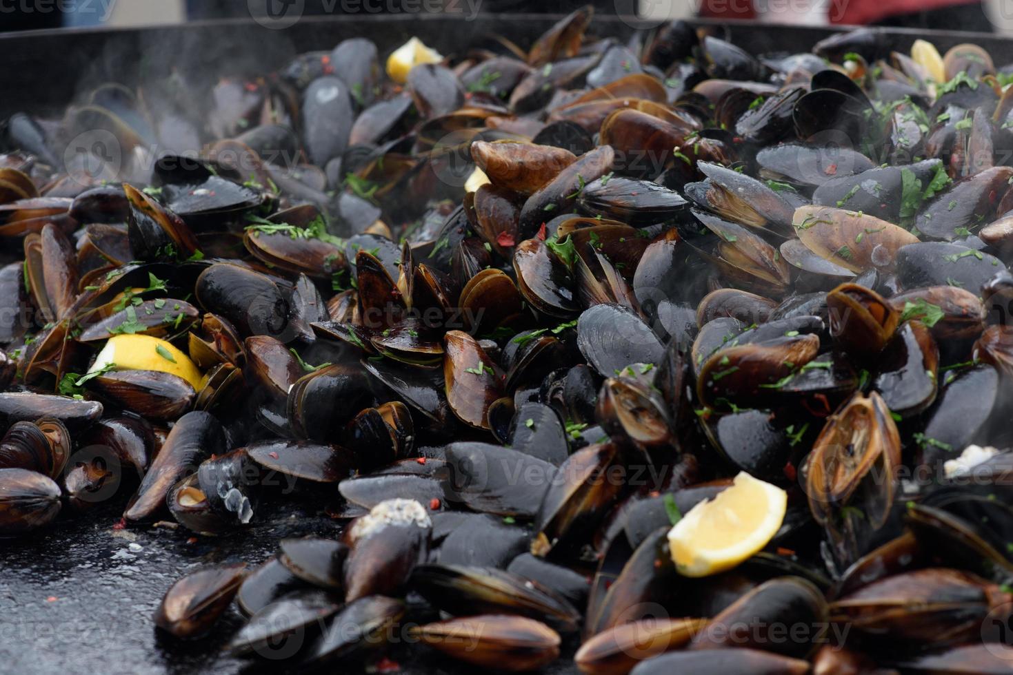 primer plano de mejillones cocidos en un festival de comida callejera, listo para comer mariscos fotografiados con enfoque suave foto