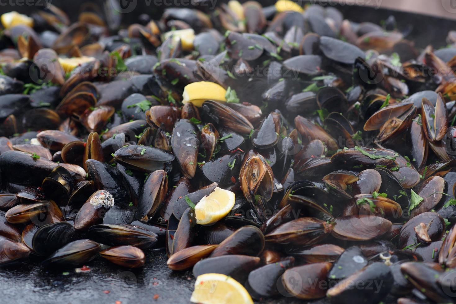 primer plano de mejillones cocidos en un festival de comida callejera, listo para comer mariscos fotografiados con enfoque suave foto