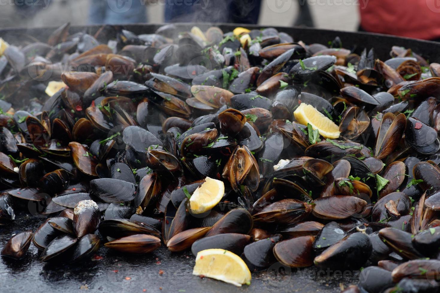 primer plano de mejillones cocidos en un festival de comida callejera, listo para comer mariscos fotografiados con enfoque suave foto