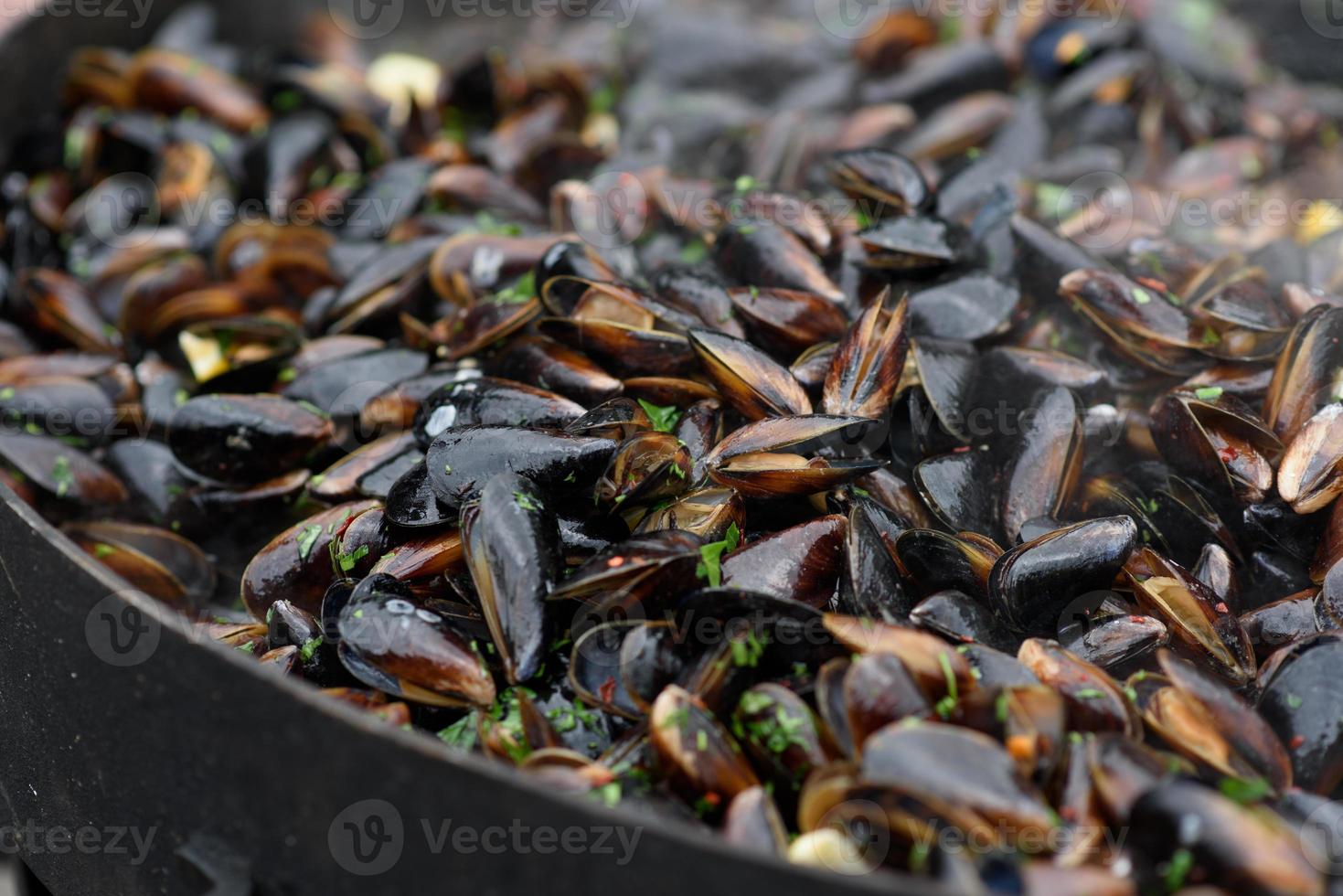 primer plano de mejillones cocidos en un festival de comida callejera, listo para comer mariscos fotografiados con enfoque suave foto