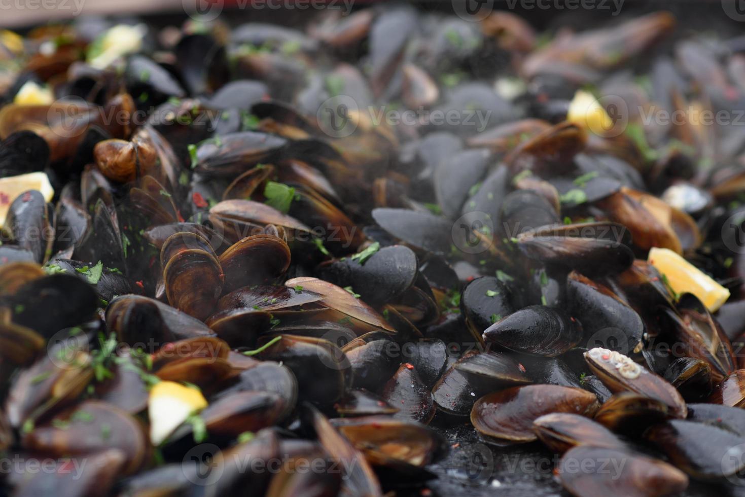 primer plano de mejillones cocidos en un festival de comida callejera, listo para comer mariscos fotografiados con enfoque suave foto