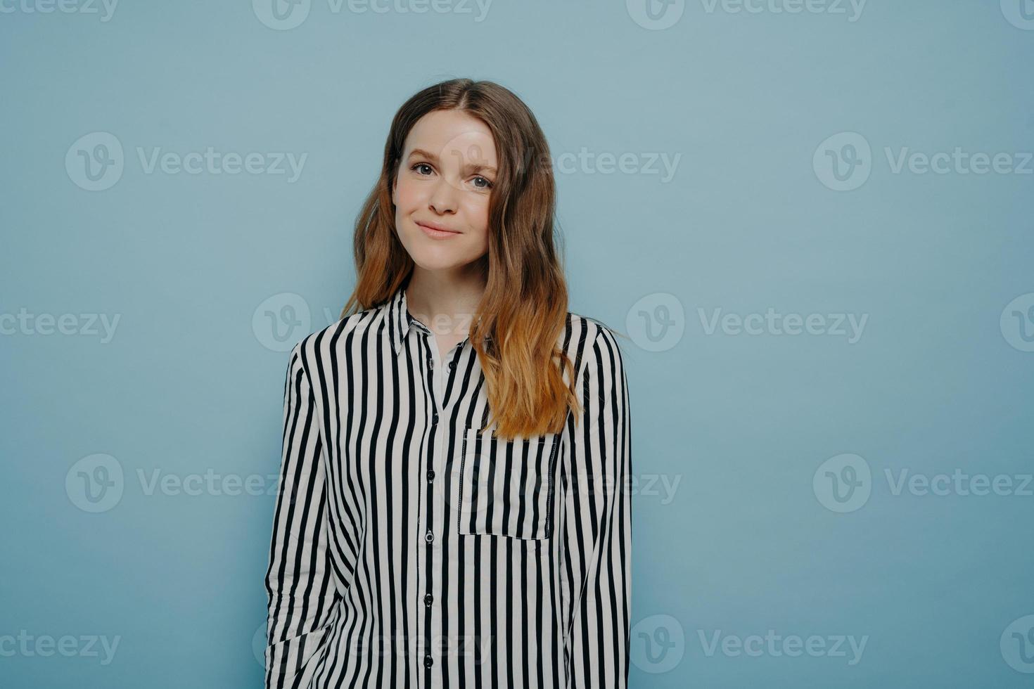 Happy teenage girl expressing good emotions while posing against blue background photo