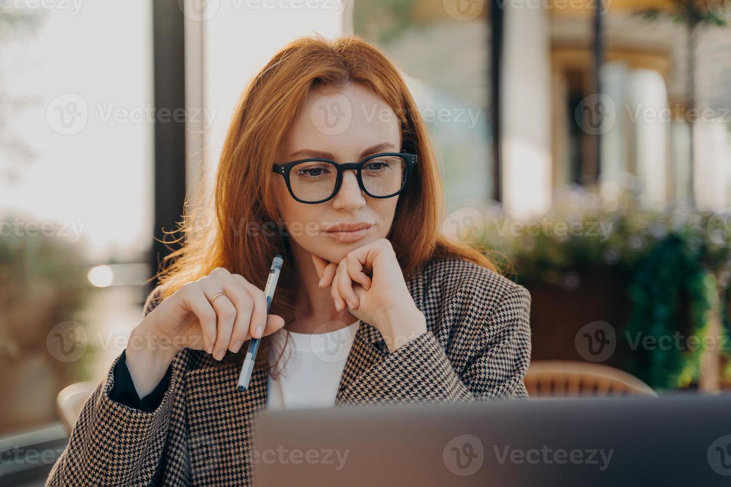 Experienced businesswoman in elegant clothes watches video about creating startup photo