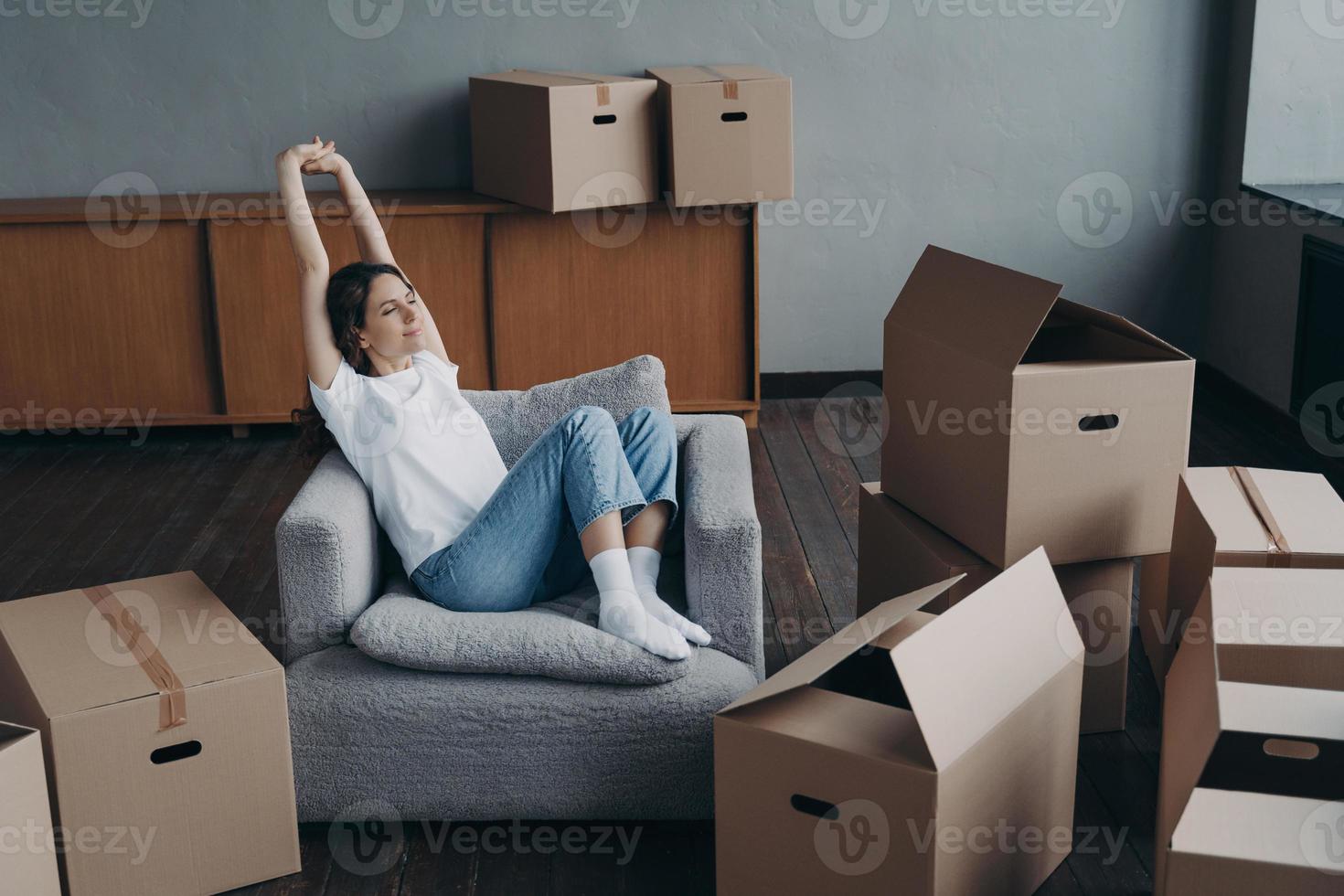 chica europea se relaja entre cajas. compra de casa de ensueño y concepto de hipoteca. foto