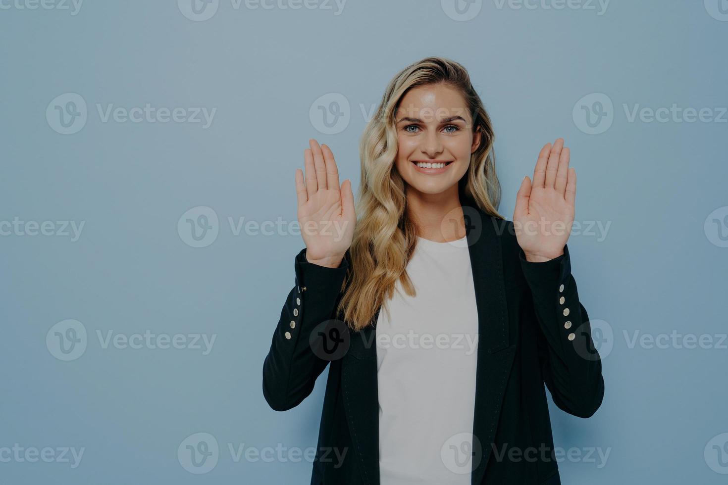 mujer que se niega de manera educada sonriendo amablemente con una mirada positiva mientras agita las manos en un gesto de alto foto