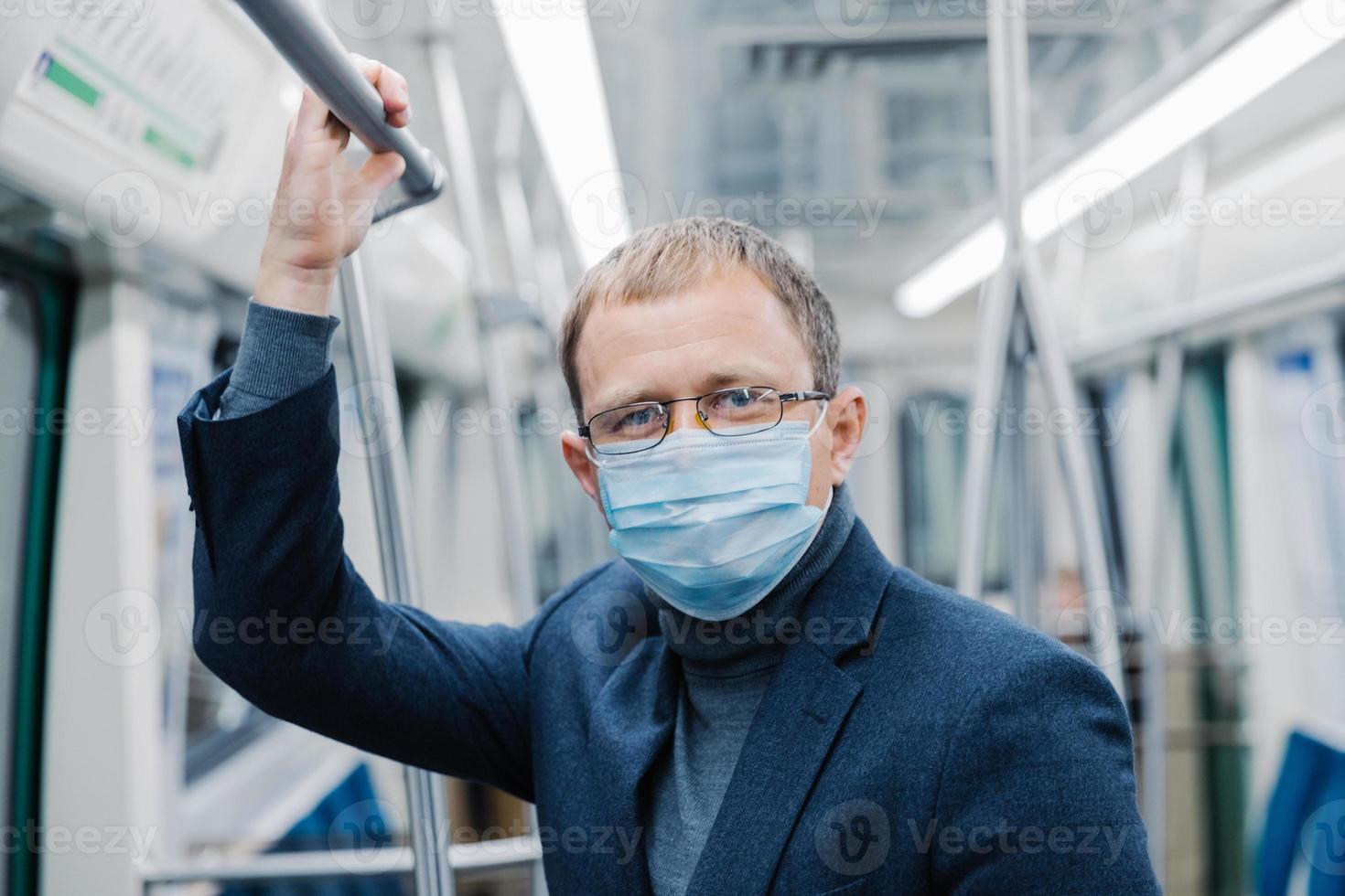prevención contra el coronavirus. el trabajador de oficina usa anteojos transparentes, atuendo formal, máscara médica, se trata de seguridad, posa en el metro, viaja en transporte público durante el brote de covid19. foto