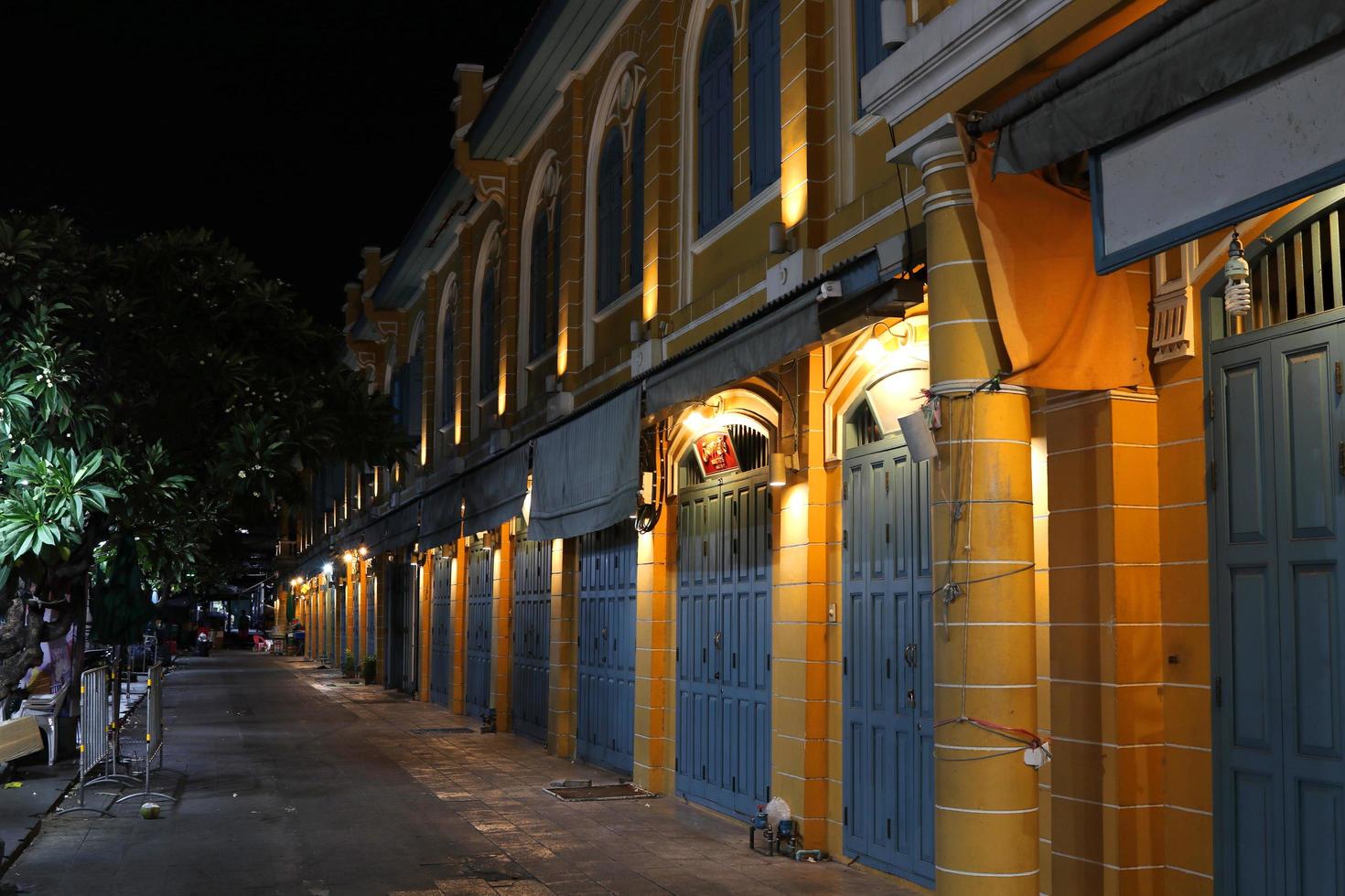 Yellow native retro building in Bangkok at night and footpath, Europe style building. photo
