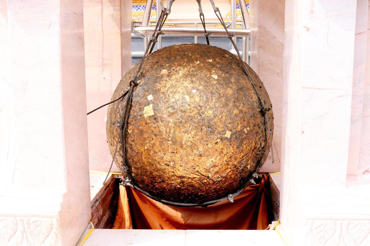 Luknimit is hanging in white cement frame and cover with gold leaves, Thailand. Luknimit is round stones buried in the ground to mark the sacred limits of a temple. photo