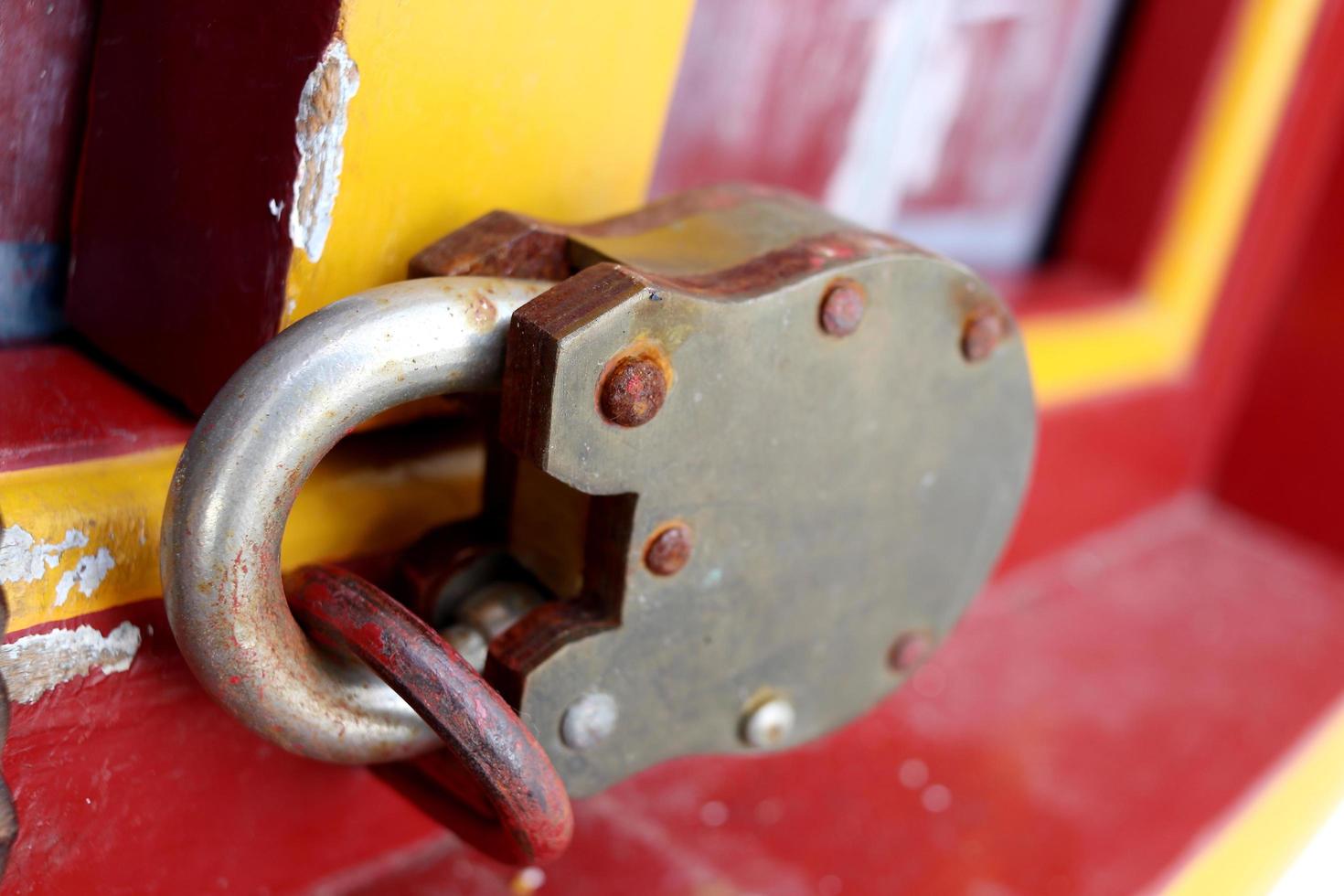 A ancient padlock is locking the wood door, old lock has rust on surface,Thailand. photo