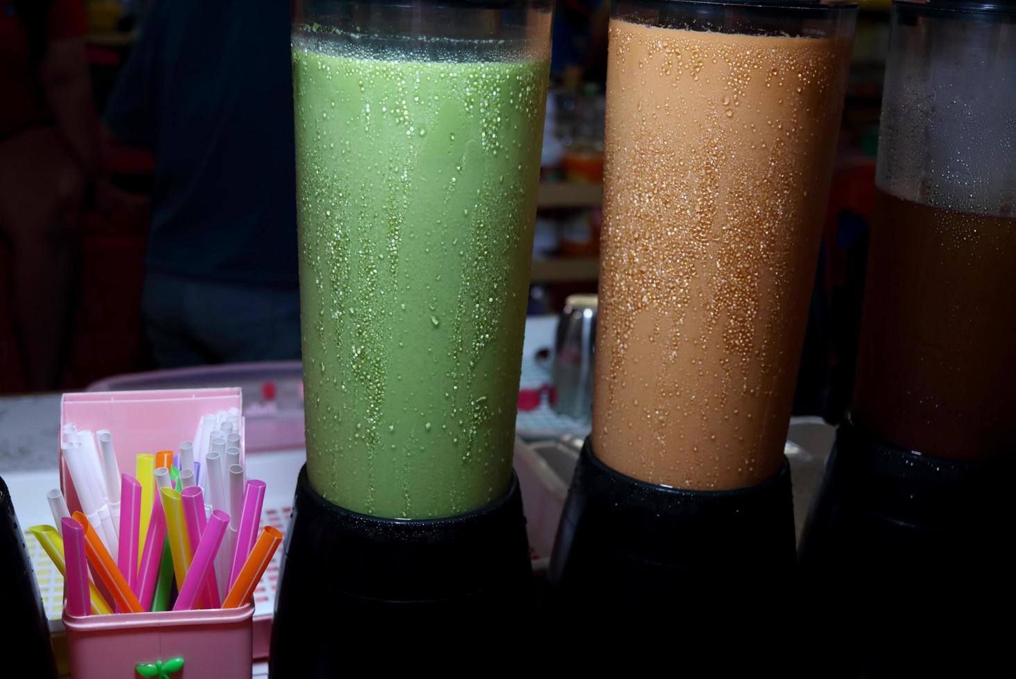 Drop of water on surface of milk tea's tube on table for sell in Thailand. In tube are green tea and Thai milk tea. photo