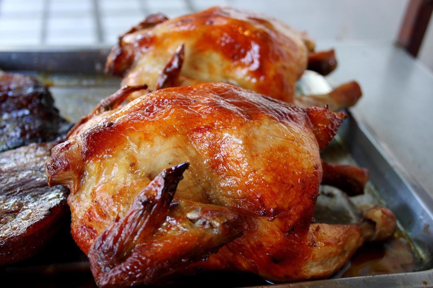 Chicken roasted in Thai style on metal tray, favorite home made style in Thailand. photo