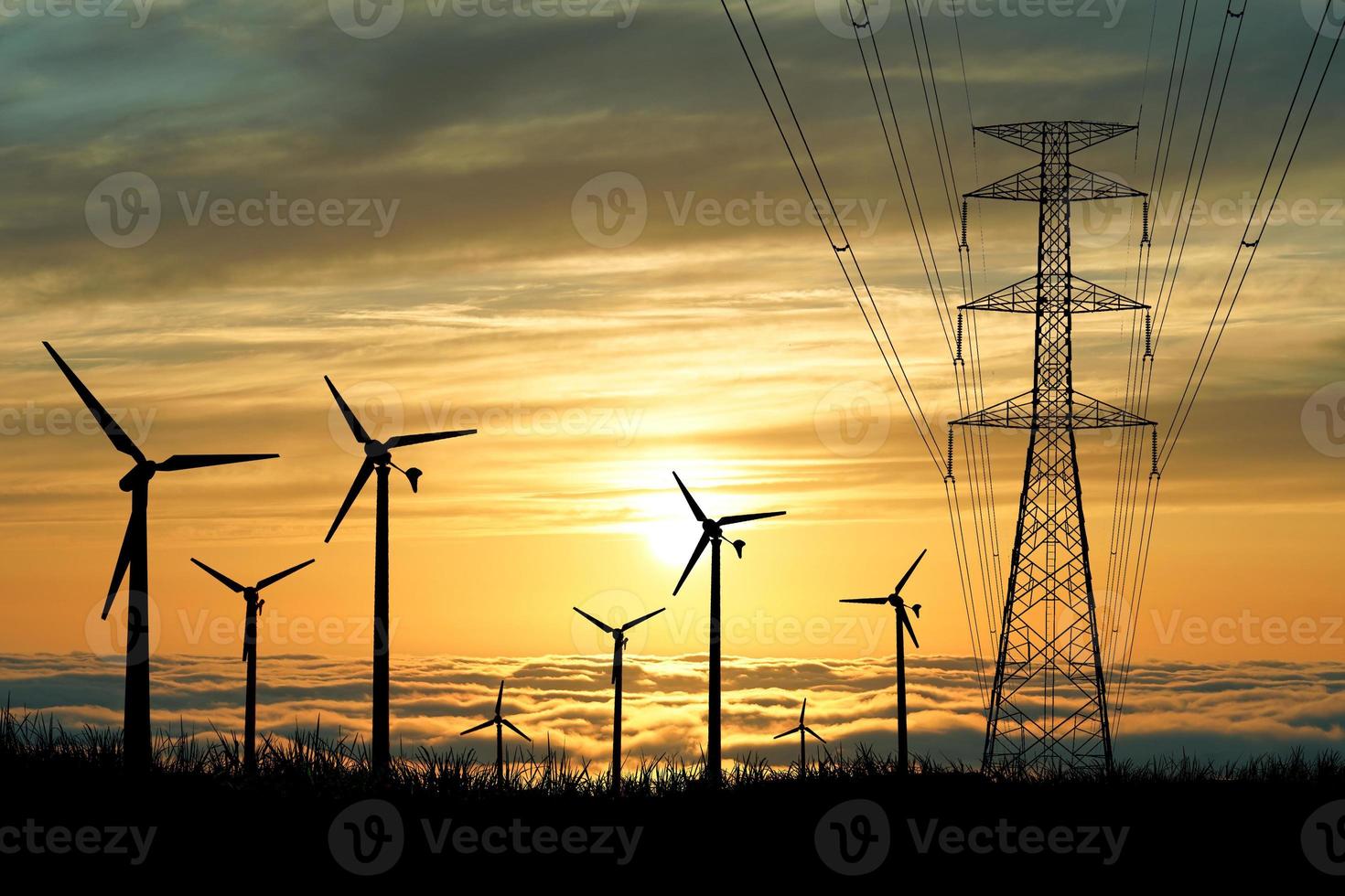 las siluetas de los aerogeneradores se utilizan para generar electricidad en los campos durante las horas de la tarde. foto