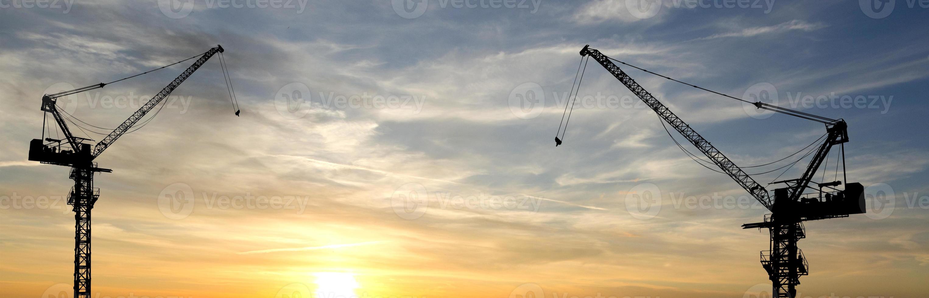 la silueta de la grúa en el sitio de construcción foto