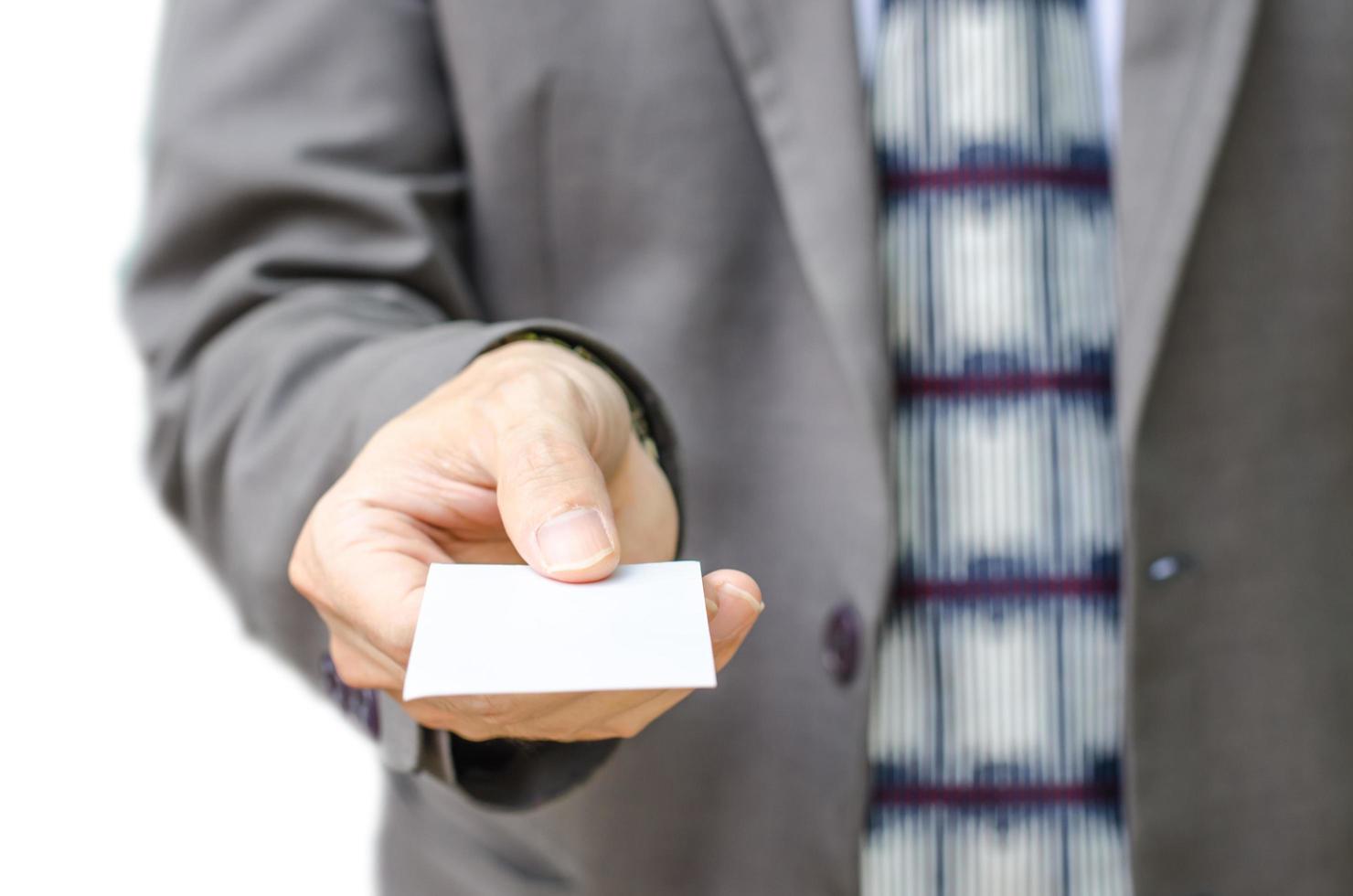 El empresario en traje gris muestra la tarjeta de visita con copia espacio, aislado en un fondo blanco. foto
