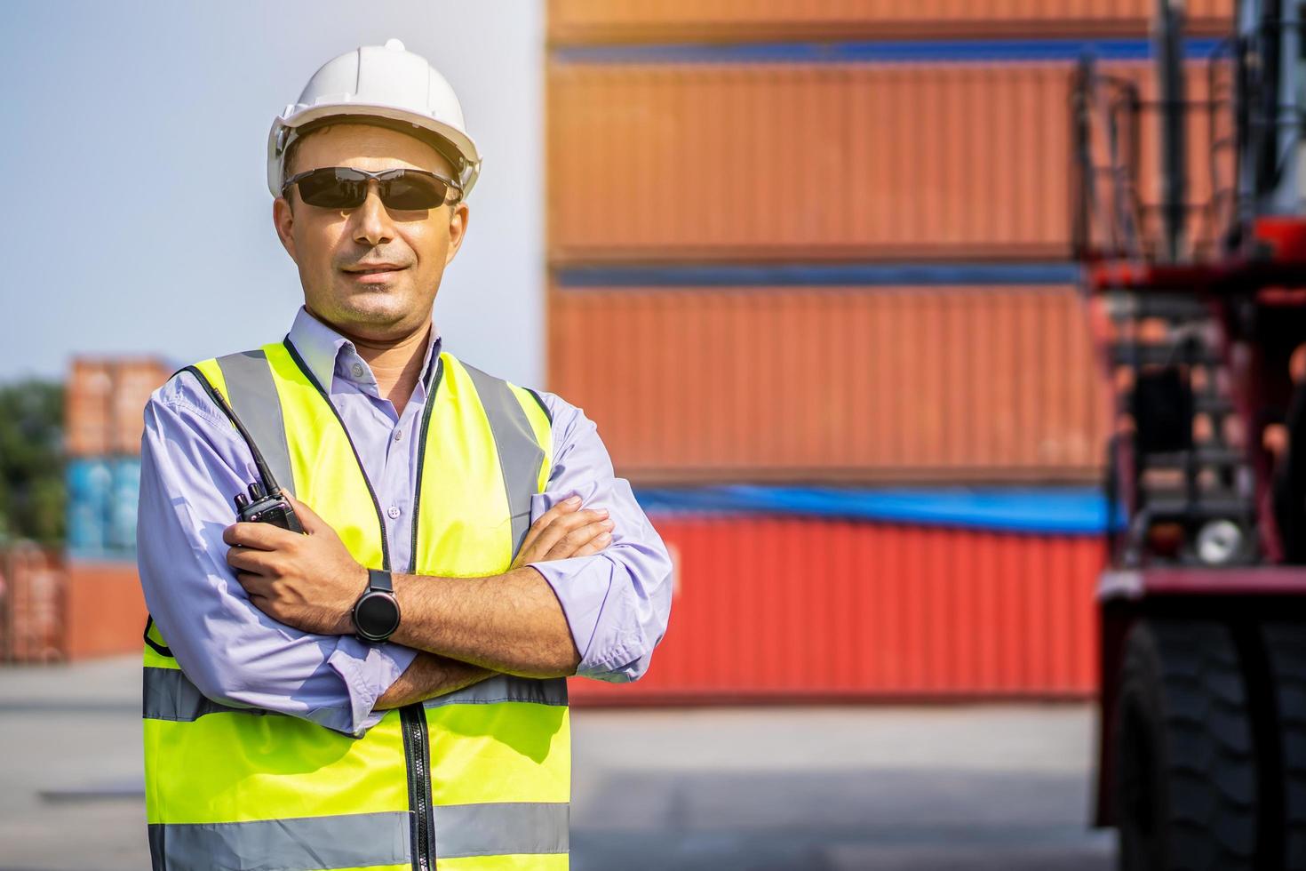 joven ingeniero o gerente que usa la comunicación por radio para controlar la carga de contenedores en conceptos de logística y transporte industrial. foto