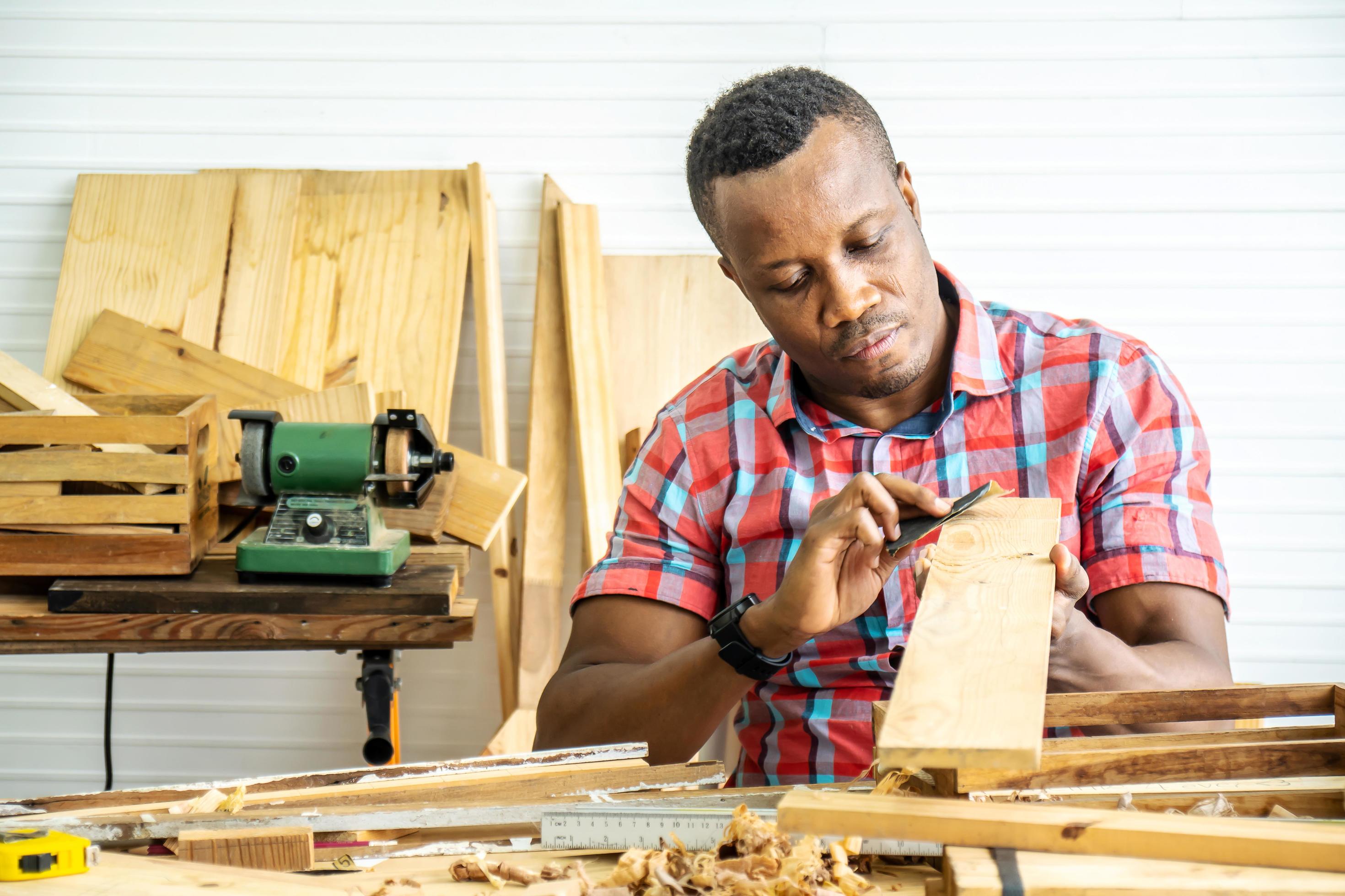 Young carpenter african american man looking and choosing wood and