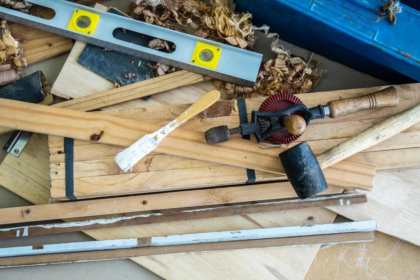 Background image of carpenters workstation, carpenters work table with different tools, wood cutting, water level gauge, paint brush with wood shavings photo